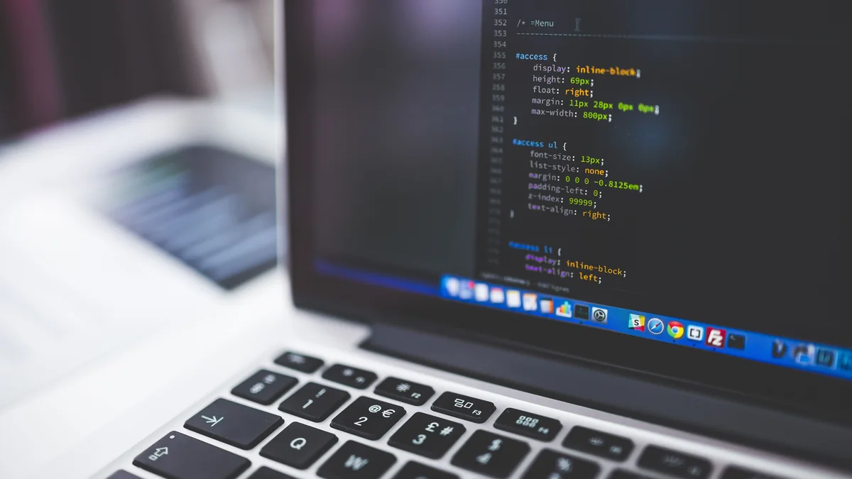 A laptop open to the code behind a website, where the structure that search engines read is built